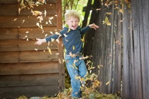 Enfant qui joue avec les feuilles